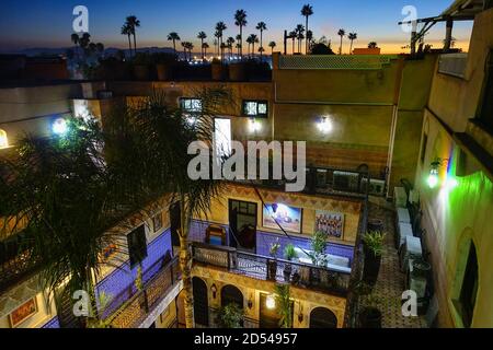 Wunderschönes marokkanisches Riad bei Sonnenuntergang mit Palmen im Hintergrund, das schönste Riad in Marrakesch Tapete Stockfoto