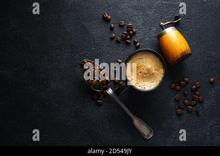 Kaffee Hintergrund mit Kaffeebohnen, Kaffee und Löffel auf dunklem Hintergrund. Blick von oben. Kaffeekonzept. Stockfoto
