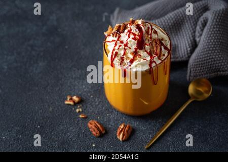 Kürbis-Smoothie serviert mit Schlagsahne und Karamell im Glas. Nahaufnahme Stockfoto