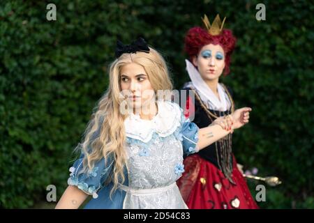 MÜNCHEN, DEUTSCHLAND - 12. Sep 2020: Cosplayer als Figuren aus Alice im Wunderland. Alice wird von der roten Königin gehalten und kontrolliert Stockfoto