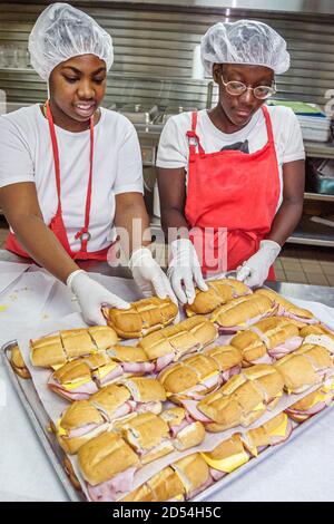 Miami Florida, Ostersieale Generationenübertag, Freiwillige in der Küche bereiten das Mittagessen vor, Mahlzeiten zuzubereiten, schwarzafrikanischer Teenager Teenager Teen Tee Stockfoto