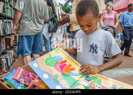 Miami Florida, Dade College Campus, Internationale Buchmesse Verkäufer Stall Bücher, Black African boy browsing Look suchen Kinderbücher, Stockfoto