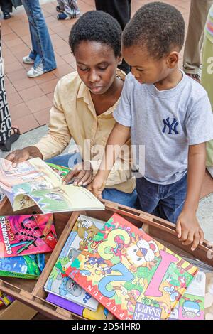 Miami Florida, Dade College Campus, Internationale Buchmesse Verkäufer Stand Verkäufer Bücher, schwarz afrikanischen Jungen Sohn Frau weibliche Mutter aussehen Kinder Stockfoto