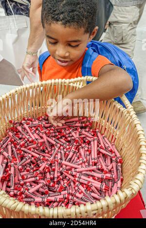 Miami Florida,Dade College Campus,Internationale Buchmesse Verkäufer Stall Bücher,Schwarze afrikanische Junge Korb Buntstifte rot, Stockfoto