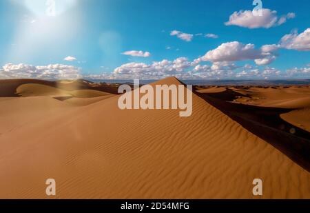Eine wunderschöne Sahara-Wüstenlandschaft in Marokko, mit einer großen Sanddüne in Form einer Pyramide in der Mitte. Stockfoto