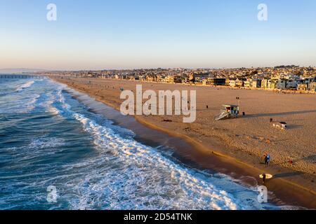 Luftaufnahme von Surfern, die bei Sonnenuntergang aus dem Meer kommen in Hermosa Beach, Kalifornien Stockfoto