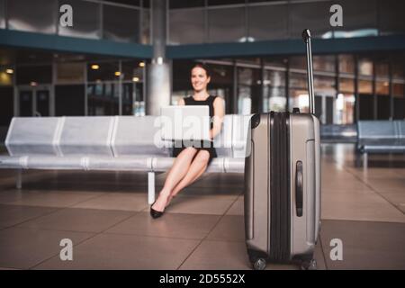 Frau, die ihr Gepäck zum Tor trägt Stockfoto