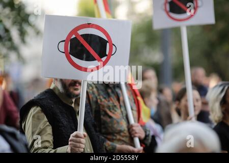 Bukarest, Rumänien - 10. Oktober 2020: Während einer politischen Kundgebung zeigen die Menschen Gesichtsschutzmasken mit Transparenten. Stockfoto