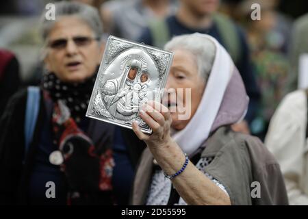 Bukarest, Rumänien - 10. Oktober 2020: Details mit einer älteren Frau, die während einer politischen Kundgebung eine orthodoxe Kirchenikone hält. Stockfoto