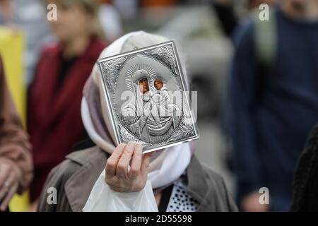 Bukarest, Rumänien - 10. Oktober 2020: Details mit einer älteren Frau, die während einer politischen Kundgebung eine orthodoxe Kirchenikone hält. Stockfoto