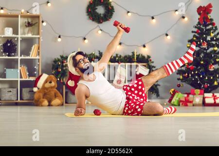 Anfänger Athlet dabei Seite liegend Bein hebt mit Hanteln während Weihnachtsurlaub zu Hause Stockfoto