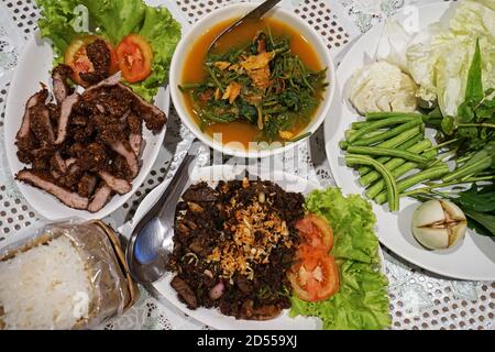 Nahaufnahme Süße Blattsuppe (Stachelbeere) Mit gebratenem Fisch serviert mit zerschlagenen gebratenen Schweinefleisch und Larb (Würziger Schweinesalat) - nordthailändische Küche Stockfoto