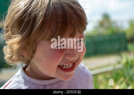 Kleine drei Jahre alten Jungen im Freien Porträt. Netter Junge machen wütend Gesicht mit Zähnen aus der Nähe Stockfoto