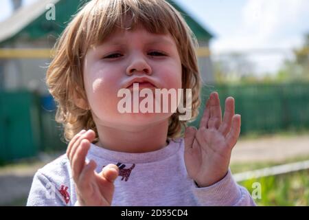 Kleine drei Jahre alten Jungen im Freien Porträt. Niedlich Junge machen lustige Gesicht Nahaufnahme Stockfoto