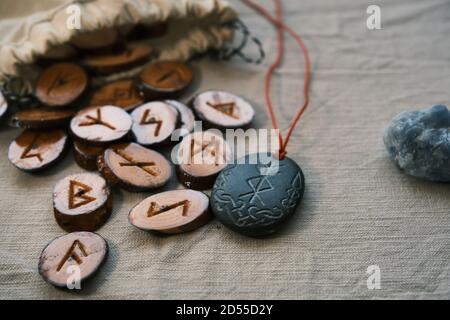 Hölzerne Runen in einem Leinwandbeutel mit einem steinernen Runescript Stockfoto