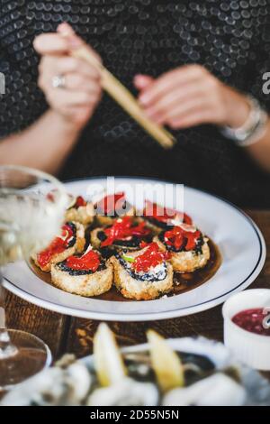 Mädchen essen gebackenes Sushi mit Essstäbchen im japanischen Restaurant Stockfoto