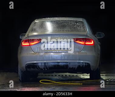 Auto bedeckt mit Schaum auf Autowäsche Stockfoto