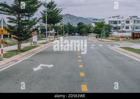 Straßenschild Gelbe gepunktete Linie, Fußgänger Kreuz Marke weiß Farbe Pfeil Richtung vorwärts rechts links Asphalt. Entfliehen Sie in einer ruhigen, leeren Straße im Stadtbezirk Stockfoto