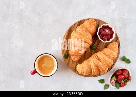 Croissants mit Erdbeermarmelade und Kaffeetasse. Draufsicht mit Kopierbereich Stockfoto