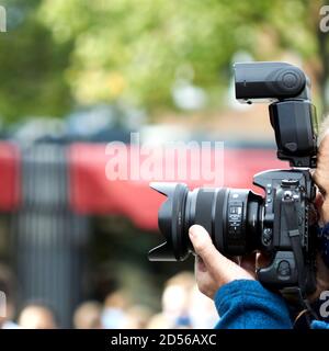 Braunschweig, 25. September 2020: Digitale Spiegelreflexkamera mit angeschlossenem Blitz wird von einem Fotoreporter verwendet Stockfoto