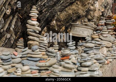 Schöne Nahaufnahme von mehreren Stein cairns sitzen auf einem viel größeren Felsen am zerklüfteten Kiesstrand an der Ostküste von Vernazza in den Cinque... Stockfoto