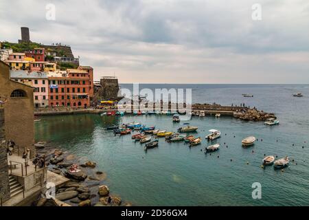 Herrlicher Panoramablick auf den charmanten Hafen von Vernazza in der Cinque Terre Küstenregion mit vielen Booten auf dem flachen Wasser verankert. Der Turm von... Stockfoto