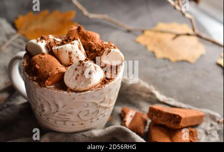 Heiße Schokolade und Marshmallows. Heißer Kakao in einer weißen Tasse. Dunkler Hintergrund. Herbstgetränk-Konzept. Speicherplatz kopieren. Stockfoto