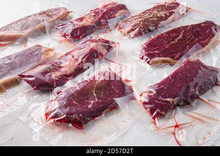 Set von Vakuum verpackt organischen rohen Rindfleisch Steaks alternative Schnitte über weißen Hintergrund, Seitenansicht. Stockfoto