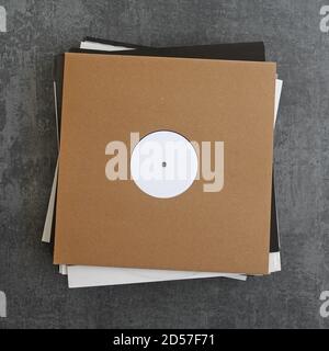 Stapel von Promo-Vinyl-Schallplatten in Papphüllen. Platzieren Sie Ihr Logo oder Bildmaterial auf dem Cover und dem weißen Etikett. Stockfoto