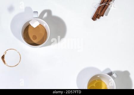 Tasse Kaffee mit Zuckerwürfel fallen in, Kaffee Tasse Fleck und Zimt sticksg. Weißer Hintergrund und Kopierbereich Stockfoto