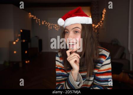 Fröhliche junge Frau in Weihnachtsmann Hut Stockfoto