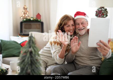 Vorderansicht des älteren Ehepaares zuhause zu Weihnachten, Selfie machen. Stockfoto