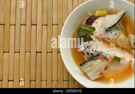 Würziger Lachsfischkopf und Strohpilz in Tom Yum Suppe auf Schüssel Stockfoto