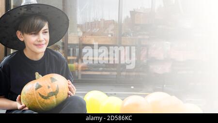 Kind in Halloween Kostüm, Hut und mit Herbstkürbissen auf Holzterrasse, halloween, Urlaub und Kindheit Konzept, Kopierraum, Banner Stockfoto