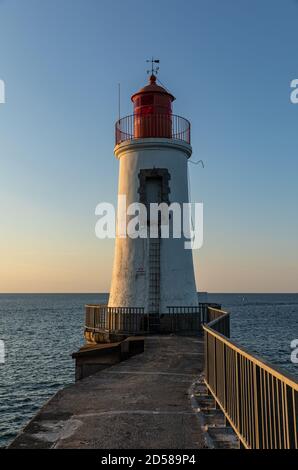 Weißer und roter Leuchtturm in Les Sables d'Olonne bei Sonnenaufgang (Vendee, Frankreich) Stockfoto