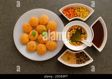 Schön angelegter Panipuri in einer kreisförmigen Glasplatte angeordnet. Panipuri, auch Golgappa genannt, ist ein indischer Straßennack. Innenaufnahme im Studio. Mo Stockfoto