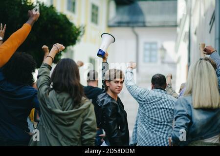 Porträt einer Frau mit Megaphon protestiert auf der Straße, Streik und Demonstrationskonzept. Stockfoto