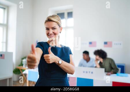 Porträt einer glücklichen Wählerin mit Tumb in Wahllokalen, usa Wahlen Konzept. Stockfoto