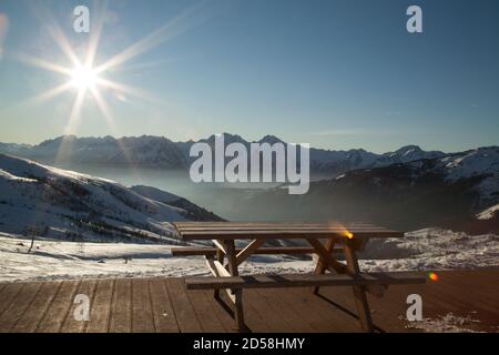 Saint-François-Longchamp : Höhe sonnigen Tag mit einem Holztisch und Boden und einem Sessellift im Hintergrund. Maurienne Savoie Stockfoto