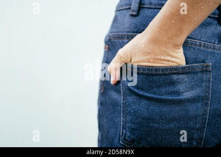 Nahaufnahme der nassen Hand einer Frau in ihrer Jeans-Tasche Stockfoto