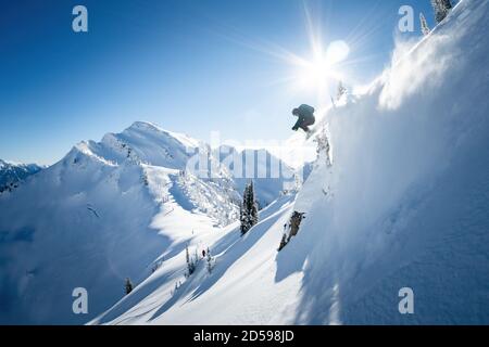 Skispringen in der Luft während Backcountry Heli Skifahren in den Kootenays, British Columbia, Kanada Stockfoto