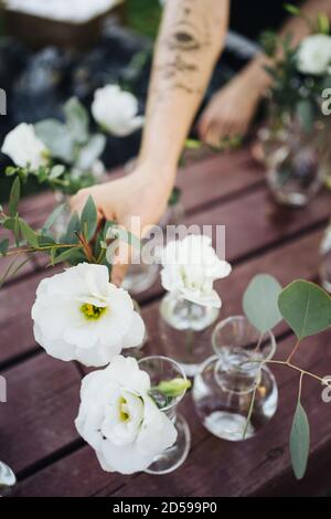 Frau, die Blumen in Vasen setzt Stockfoto