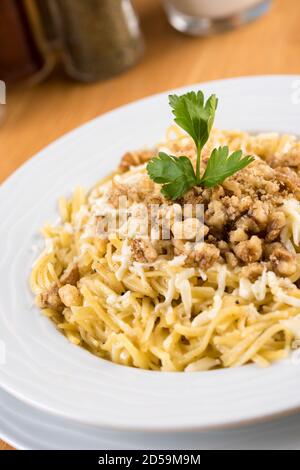 Türkischer Noodle / Eriste mit Käse, Walnüsse auf Holzhintergrund Stockfoto