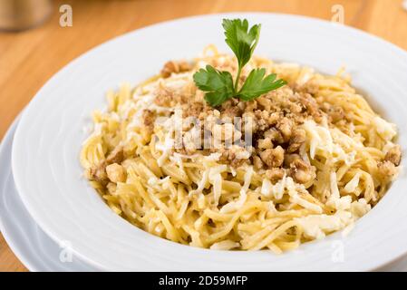 Türkischer Noodle / Eriste mit Käse, Walnüsse auf Holzhintergrund Stockfoto
