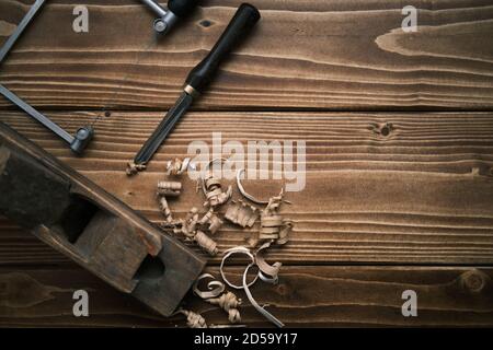 Blick von oben auf einen alten Hobel und andere alte Tischler Werkzeuge in der Schreinerei om einem Holztisch Stockfoto
