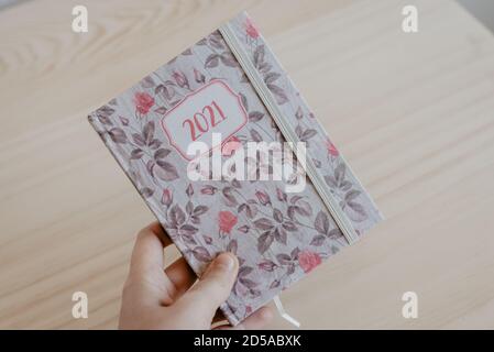Ein Mann greift eine Agenda des Jahres 2021 auf und bereitet sich auf das neue Jahr vor Stockfoto