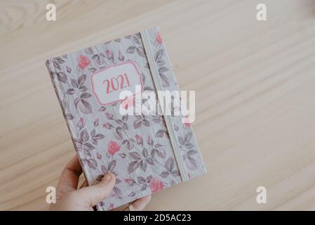 Ein Mann greift eine Agenda des Jahres 2021 auf und bereitet sich auf das neue Jahr vor Stockfoto