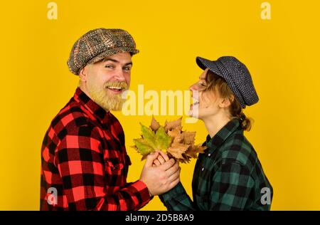 Herbst Spaß. Retro paar Bauern. Erntezeit. Thanksgiving Herbstferien. In Herbstfarben. Ahornsirup wird hergestellt. Kanada. Fallende Blätter, Herbst florale Elemente. Bärtige Mann und Mädchen Peaked Mütze. Stockfoto