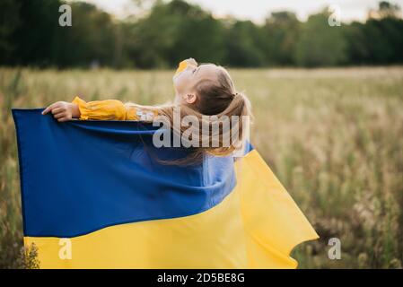 Mädchen blau-gelbe Flagge der Ukraine in das Feld ein. Die Unabhängigkeit der Ukraine Flag Tag. Der Tag der Verfassung. Am 24. August. Patriotische Urlaub. Stockfoto