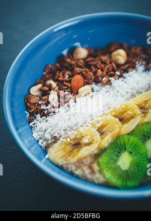 Vegetarisches Frühstück Mahlzeit mit gesunden Früchten, Vollkorn Hafer, Nüsse vorbereitet.natürliche vegane Mittagessen Gekocht mit natürlichen Zutaten.Sliced Kiwis, Bananen, n Stockfoto